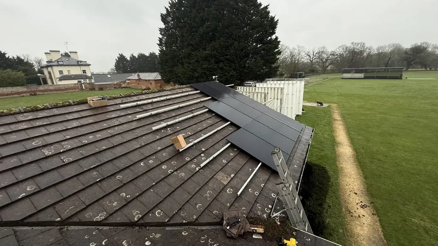 Mounting rails and fixings set out across a roof with the first panels going on