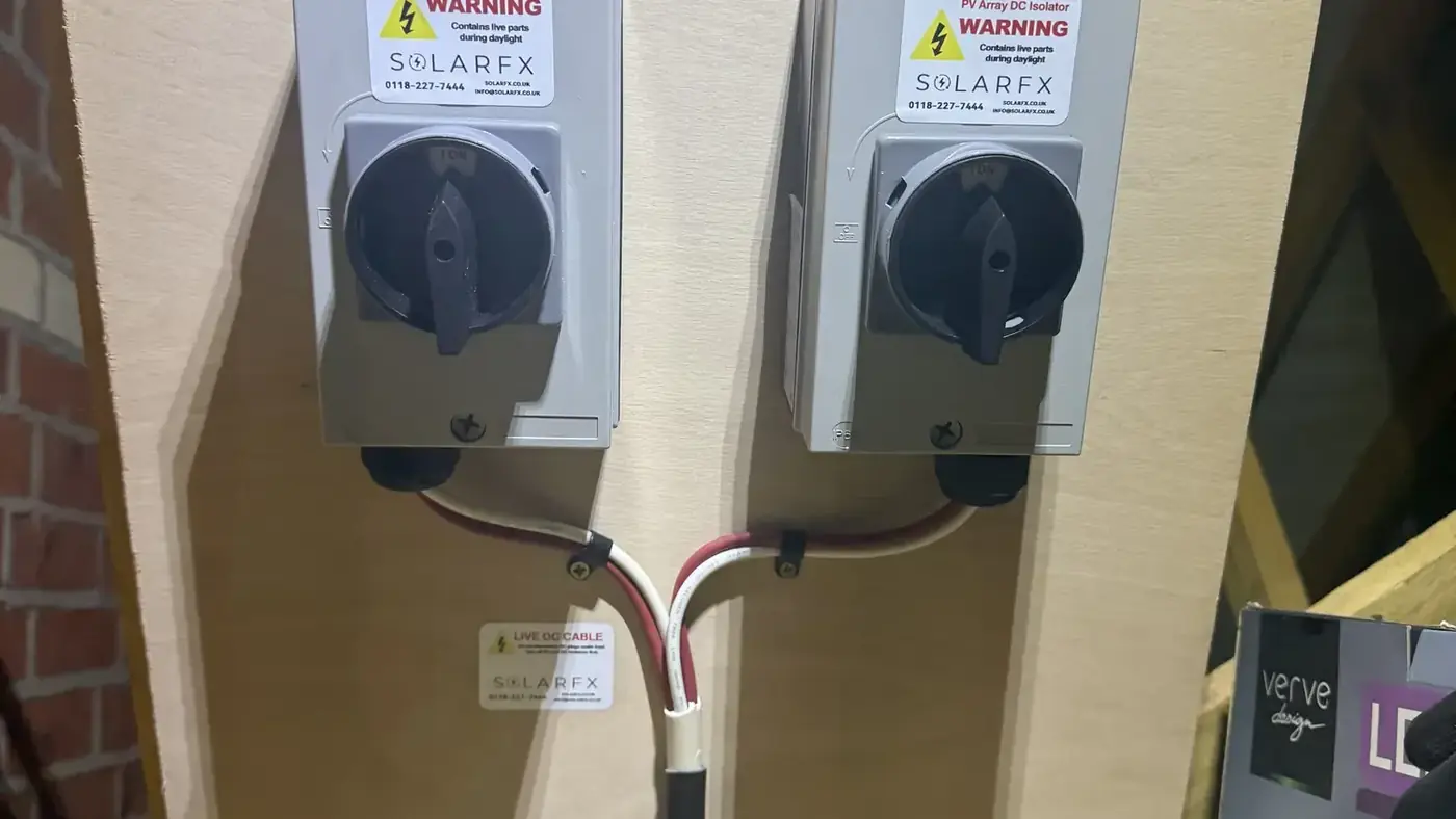 Two labelled PV DC isolators mounted on a board