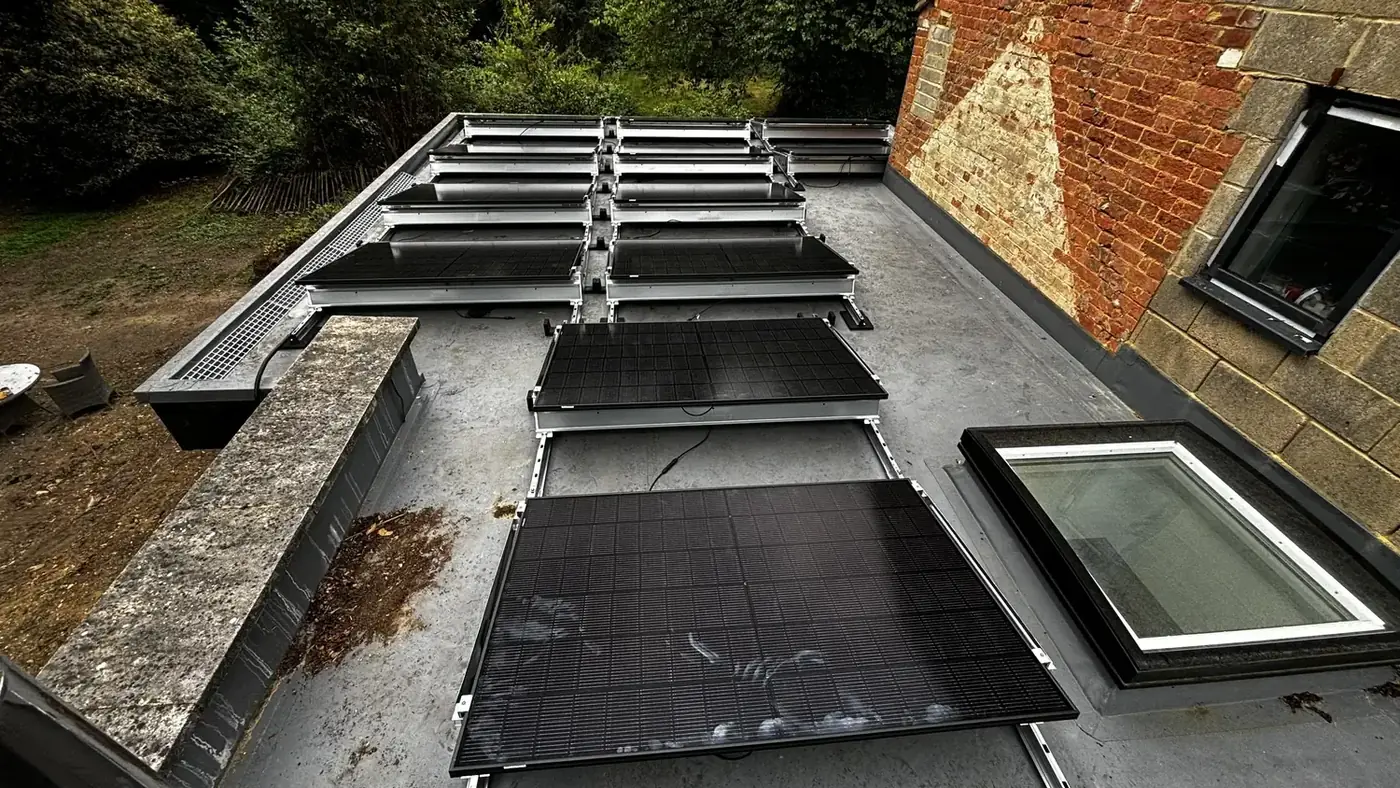 Flat roof with solar panels being fitted between rooflights