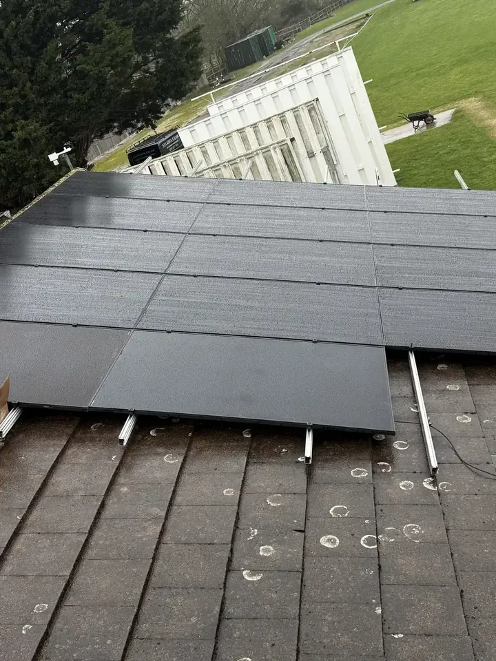 Black AIKO solar panels being laid out across a roof in Bath Road, Reading